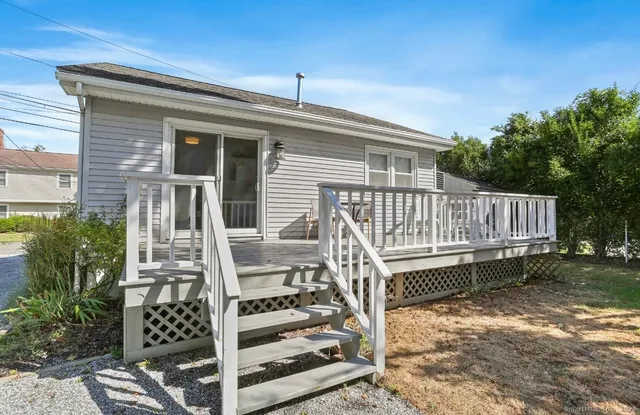 a view of a wooden house with a large window and wooden fence