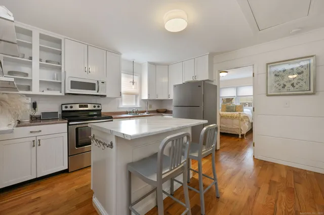 a kitchen with a refrigerator and a stove top oven