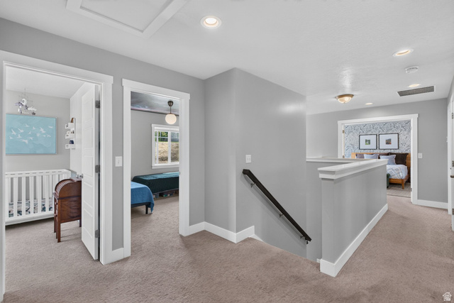 1263 East 1200th South Springville, UT 84663 - Photo 26 of 60 Carpeted hallway featuring light gray walls, white trim, recessed lighting, and a black handrail descending to a lower level