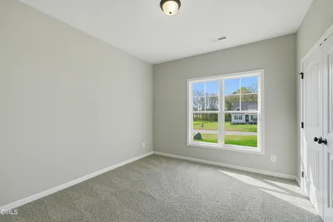 an empty room with a window and a mirror