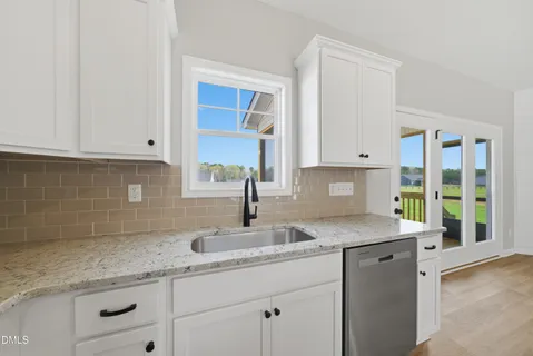 a kitchen with granite countertop white cabinets and a sink