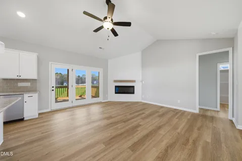 a view of an empty room with window and wooden floor