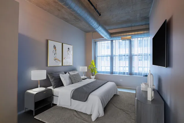 a bedroom with a bed and a flat tv screen on dresser