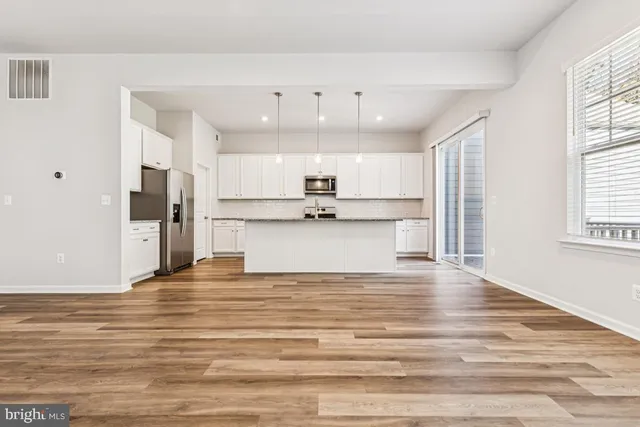 a view of kitchen with granite countertop cabinets and refrigerator