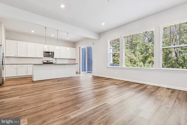 a view of kitchen with wooden floor and electronic appliances