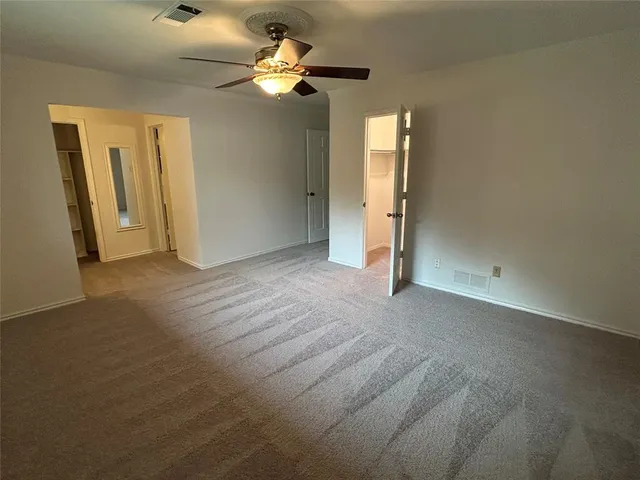 an empty room with closet and a chandelier fan