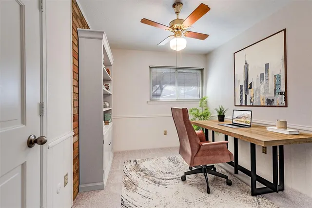a view of a bedroom with a window and a ceiling fan