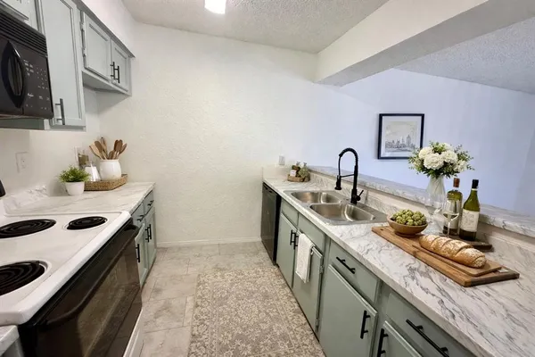 a kitchen with sink stove and cabinets