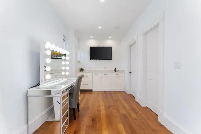 a view of a kitchen with wooden floor and electronic appliances