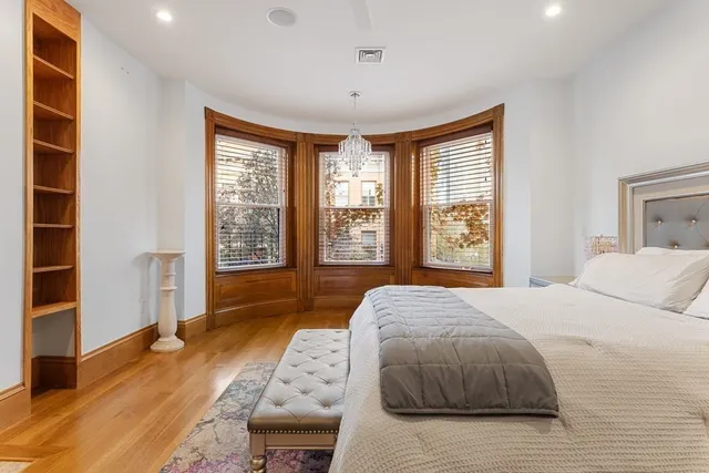 a bedroom with a bed and a large window with the outer view