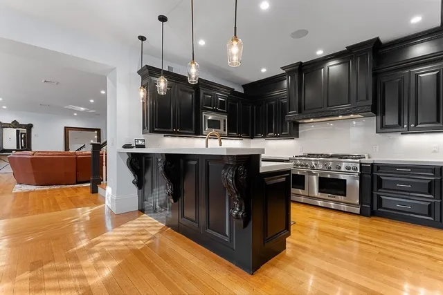a kitchen with stainless steel appliances kitchen island granite countertop a refrigerator and a stove top oven