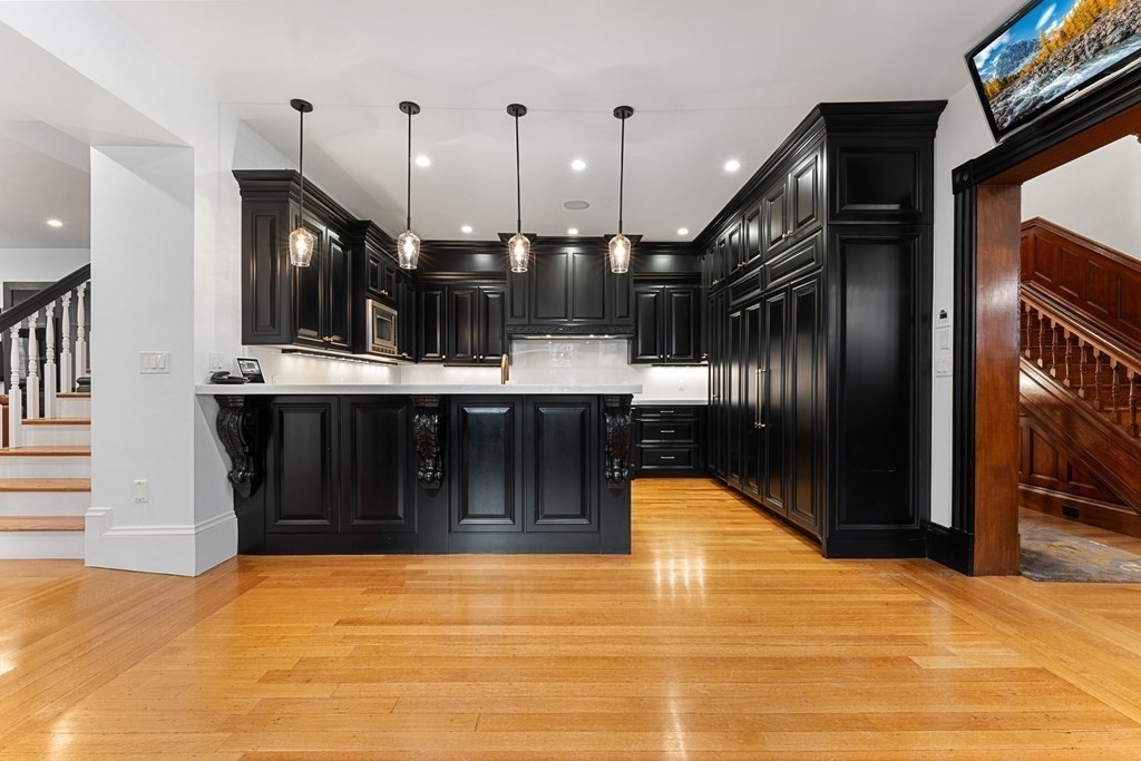 136 St Botolph Street Boston, MA 02115 - Photo 29 of 40 a kitchen with stainless steel appliances kitchen island granite countertop a refrigerator and a stove top oven
