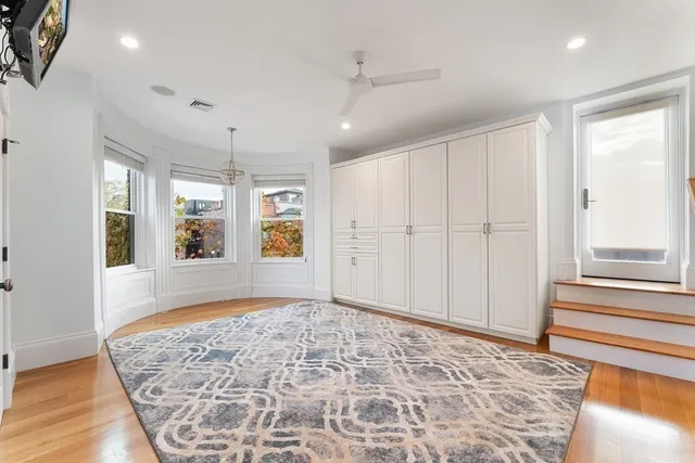 a view of a hallway with wooden floor and a living room