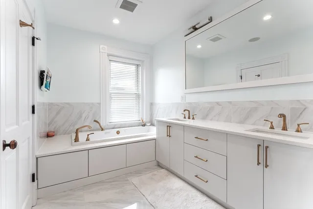 a bathroom with a sink double vanity and tub