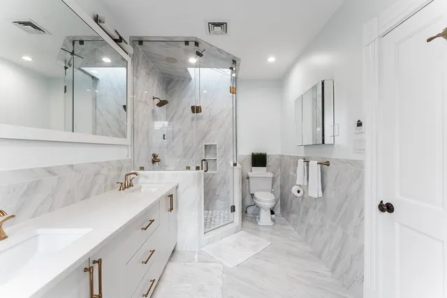 a spacious bathroom with a double vanity sink mirror and shower