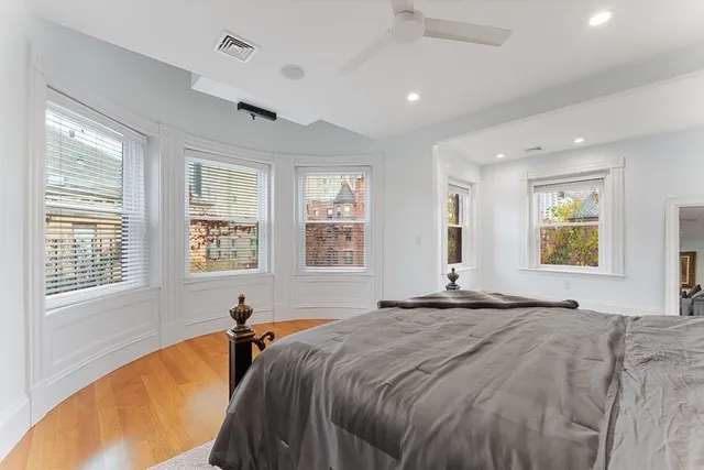 a bed sitting in a spacious bedroom next to a window