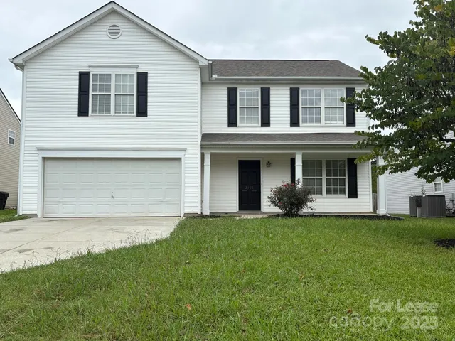 a front view of a house with a garden and yard