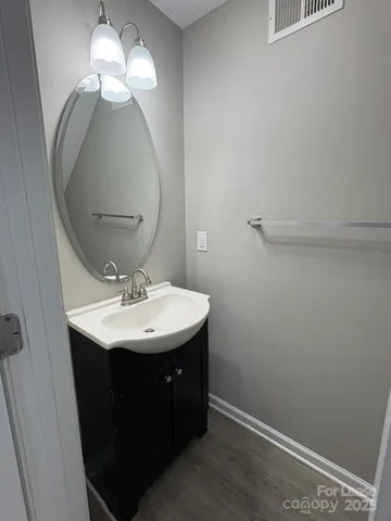 a bathroom with a sink a light fixture and a mirror