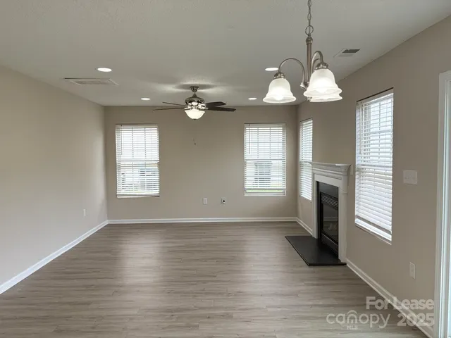 a view of a room with wooden floors and chandelier