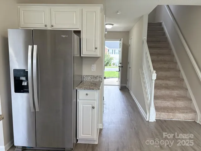 a view of a kitchen with wooden floor and electronic appliances