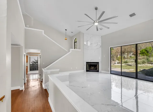 a view of a livingroom with a ceiling fan window and wooden floor