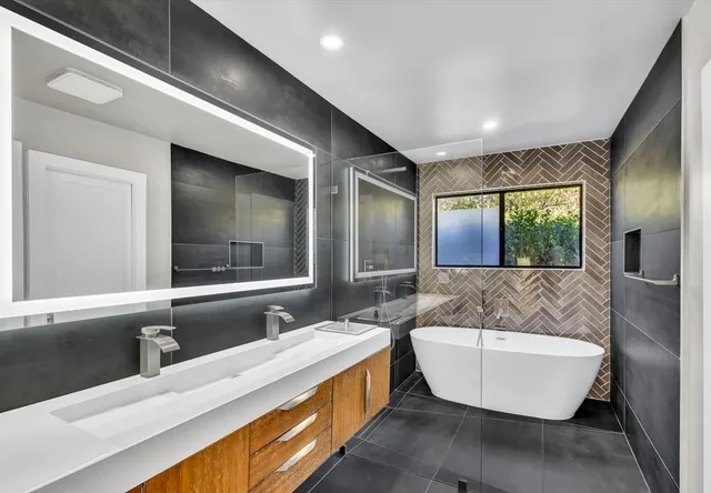a bathroom with a large tub sink and mirror