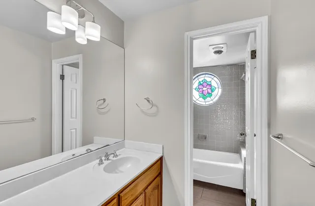 a bathroom with a sink a tub and a mirror