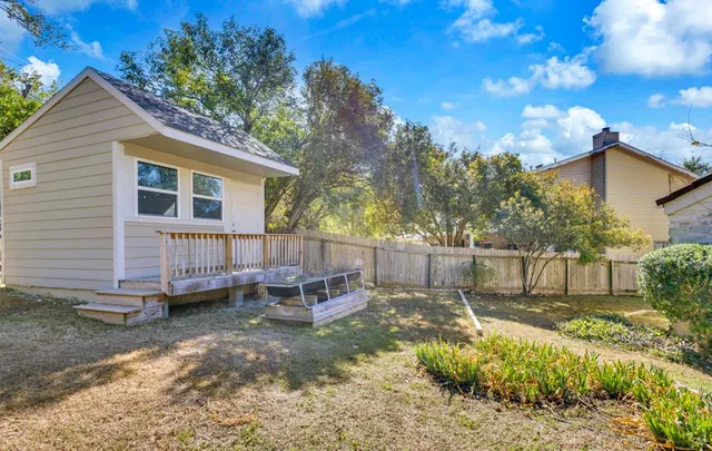 a view of a house with backyard and sitting area