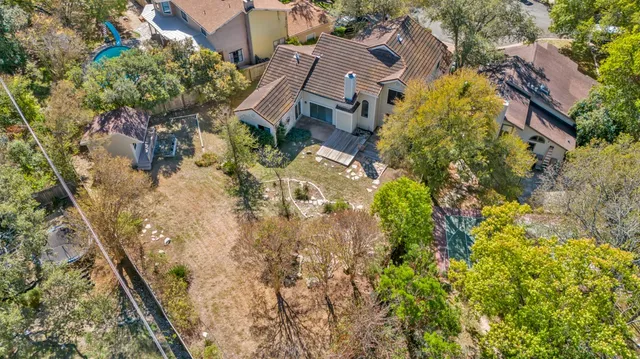 an aerial view of residential houses with outdoor space and trees