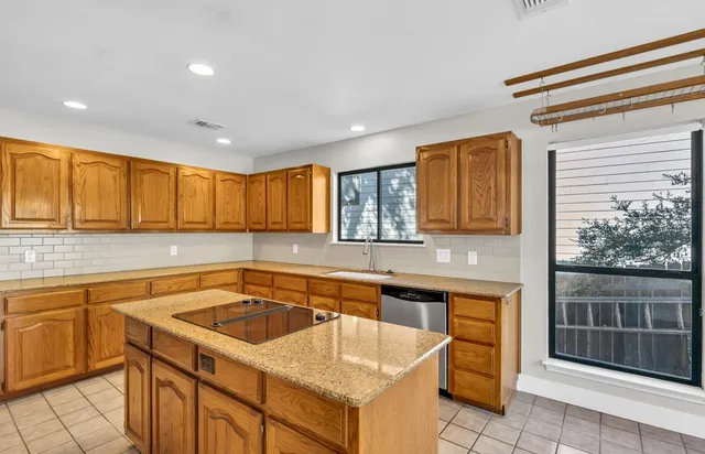a kitchen that has a sink and a stove top oven