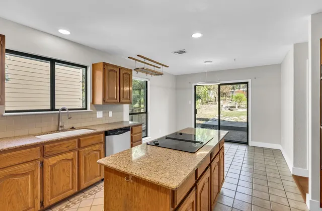 a kitchen with a stove sink and cabinets
