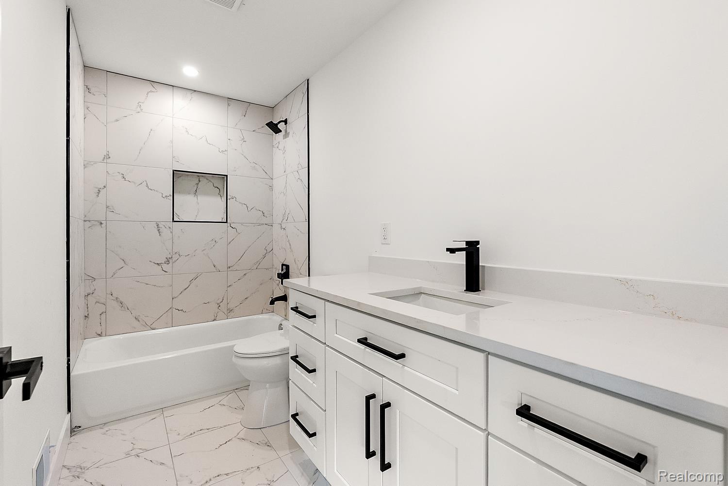 13392 Belsay Road Millington, MI 48746 - Photo 14 of 18 White vanity with a single basin sink, matte black faucet, and white quartz countertop