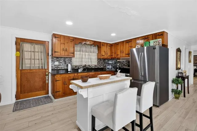 a kitchen with stainless steel appliances granite countertop a refrigerator a stove and a sink
