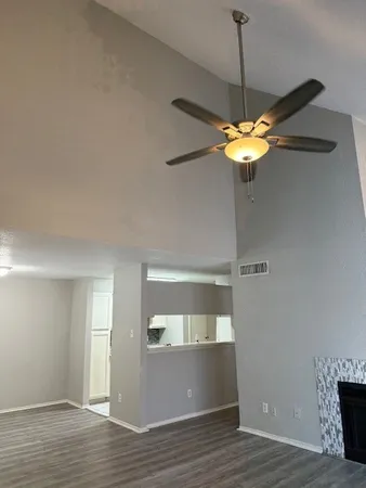 a view of a room with wooden floor and a ceiling fan
