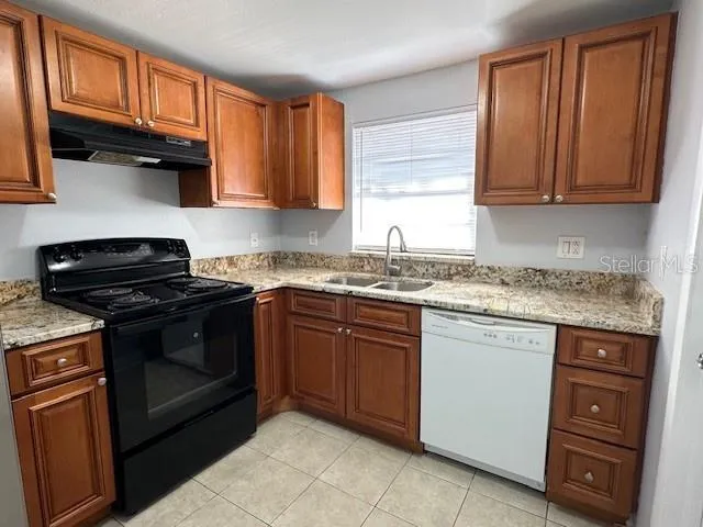 a kitchen with granite countertop cabinets stainless steel appliances and a window