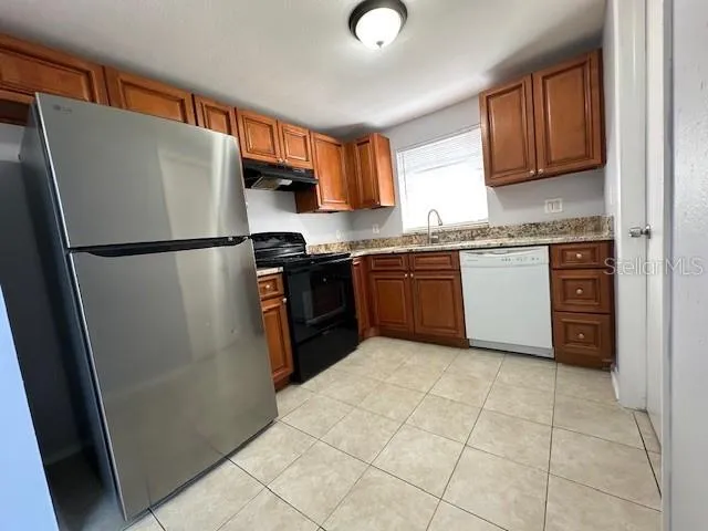 a kitchen with stainless steel appliances granite countertop a refrigerator sink and cabinets