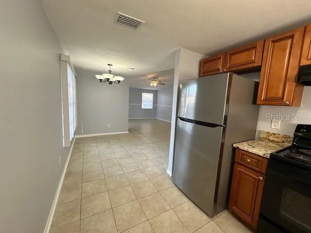 a kitchen with granite countertop a refrigerator and a sink