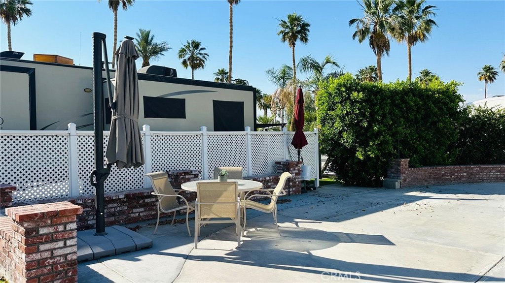 69411 Ramon Road Cathedral City, CA 92234 - Photo 4 of 12 a view of a patio with table and chairs potted plants with wooden fence