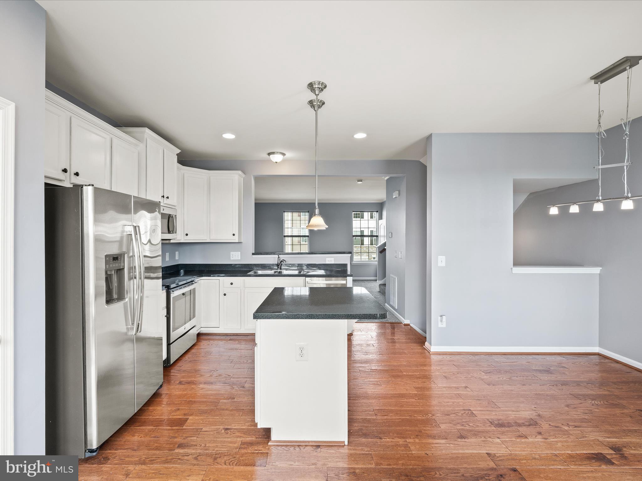 247 Schramm Loop Stephens City, VA 22655 - Photo 11 of 34 a kitchen with stainless steel appliances granite countertop a refrigerator a oven a sink and white cabinets with wooden floor