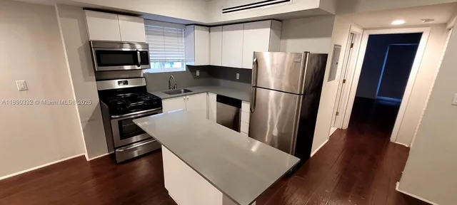 a kitchen with stainless steel appliances a refrigerator a stove a microwave and cabinets