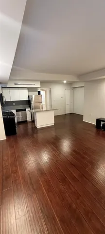 a view of a room with gym equipment and wooden floor