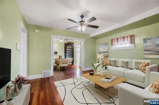 a living room with furniture and a flat screen tv with wooden floor