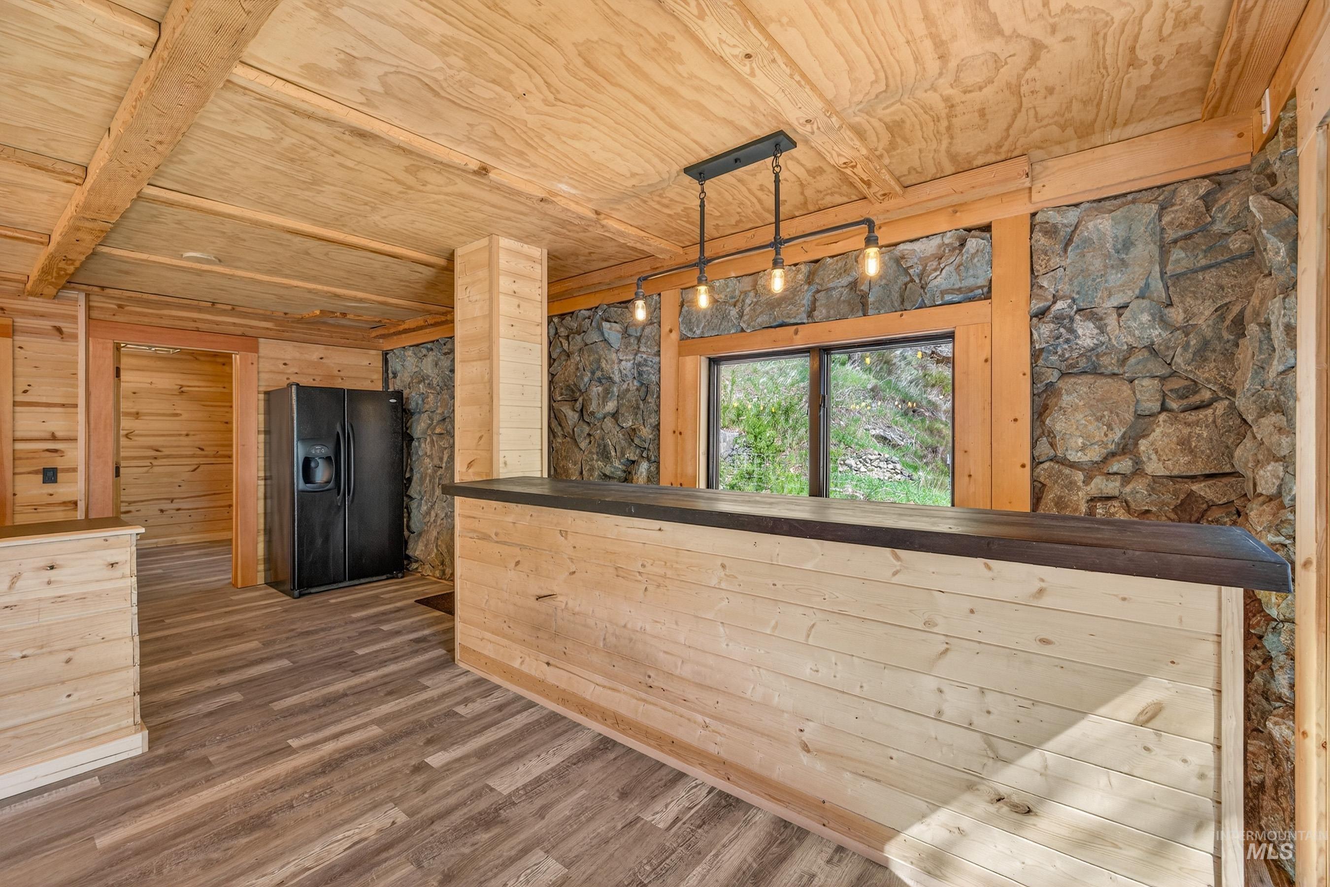 543 North Main Street Riggins, ID 83549 - Photo 12 of 46 Unfurnished dining area with a wood ceiling with exposed beams, dark wood-type flooring, and wooden walls