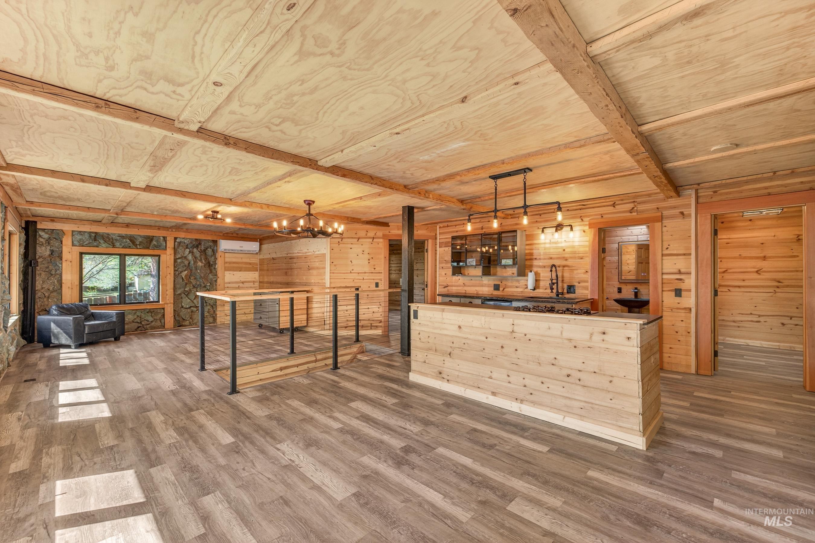 543 North Main Street Riggins, ID 83549 - Photo 13 of 46 Unfurnished living room featuring wooden walls, wood finished floors, hanging lights, and beamed ceiling