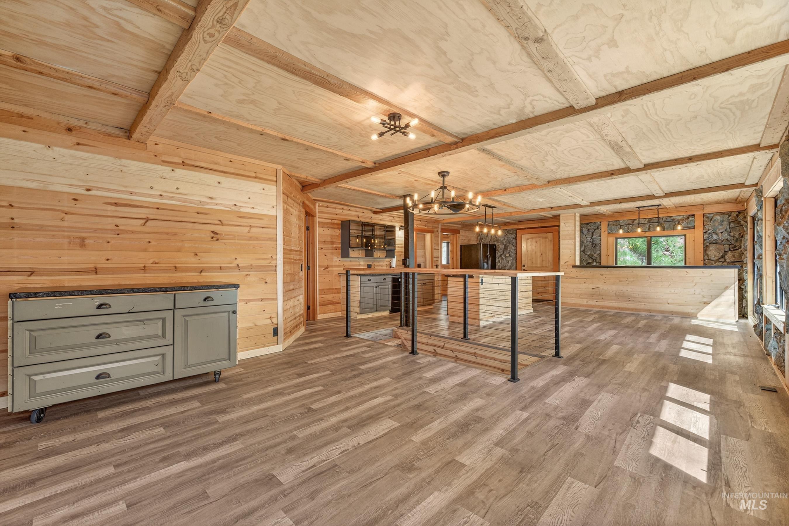 543 North Main Street Riggins, ID 83549 - Photo 15 of 46 Unfurnished living room with wooden walls, light wood-style floors, and hanging lights