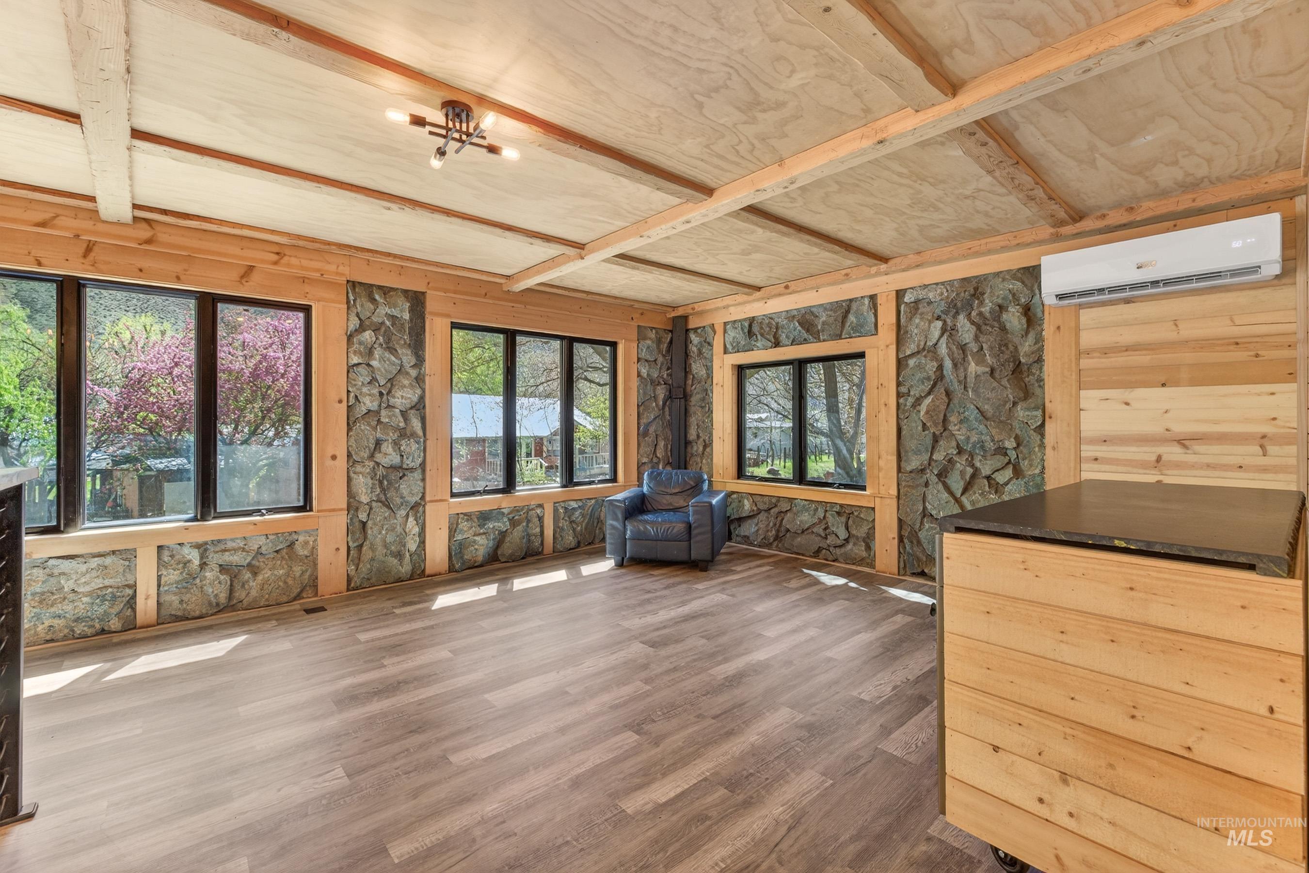 543 North Main Street Riggins, ID 83549 - Photo 17 of 46 Unfurnished room with dark wood-type flooring, wooden walls, beam ceiling, and a chandelier