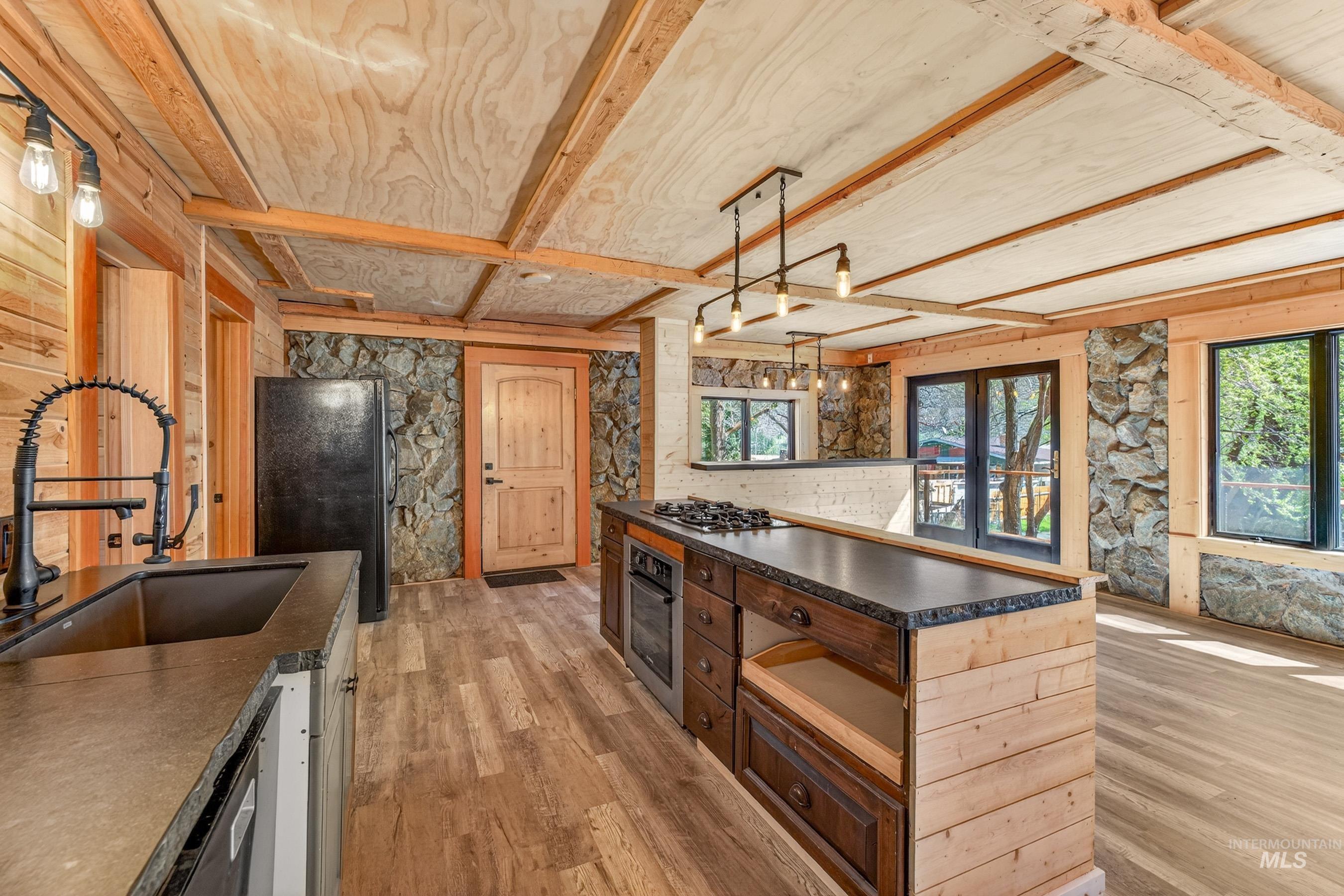 543 North Main Street Riggins, ID 83549 - Photo 18 of 46 Kitchen featuring dark countertops, pendant lighting, stainless steel appliances, light wood finished floors, and healthy amount of natural light