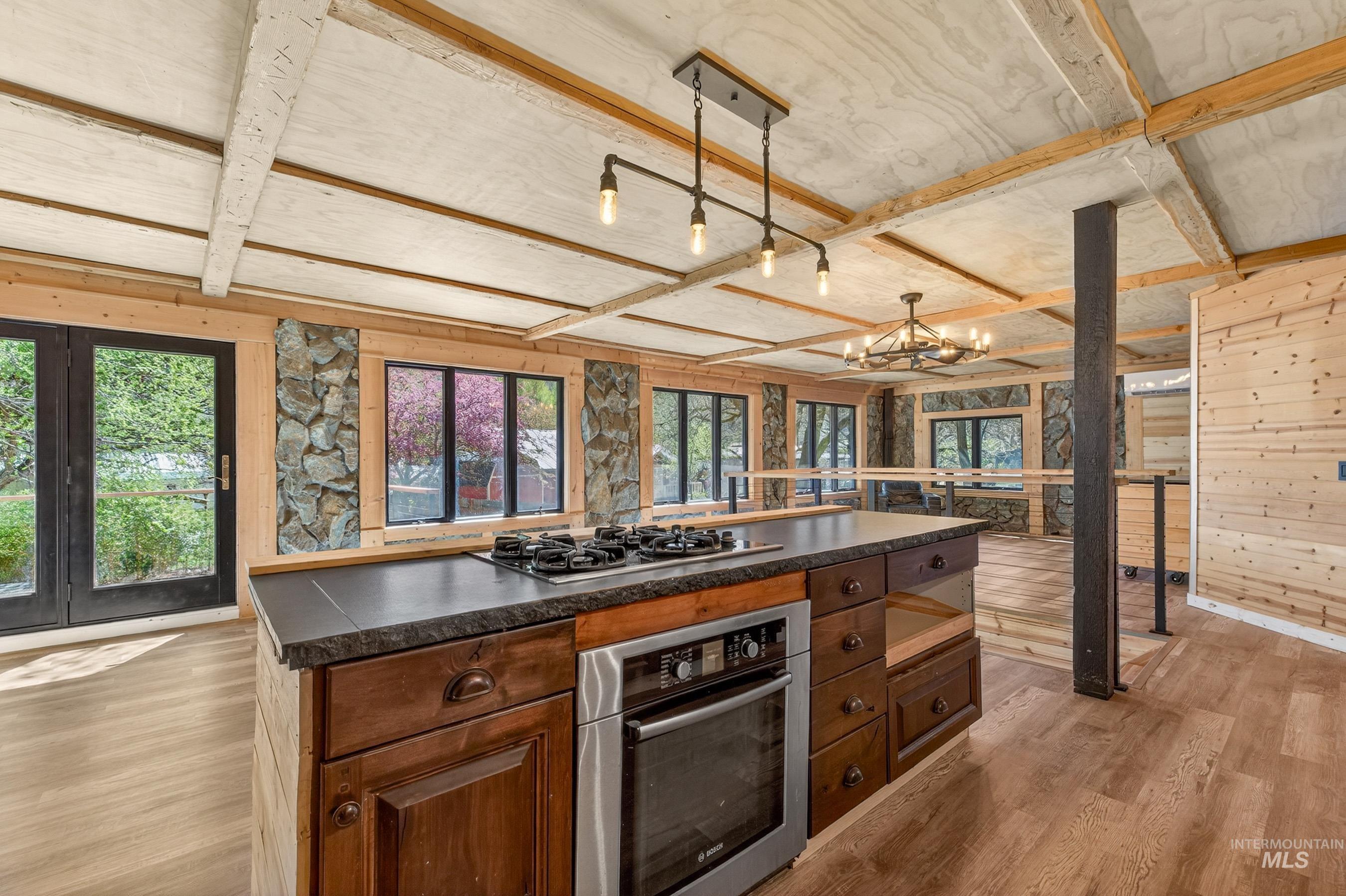543 North Main Street Riggins, ID 83549 - Photo 19 of 46 Kitchen featuring dark countertops, stainless steel oven, wooden walls, light wood-style floors, and gas cooktop