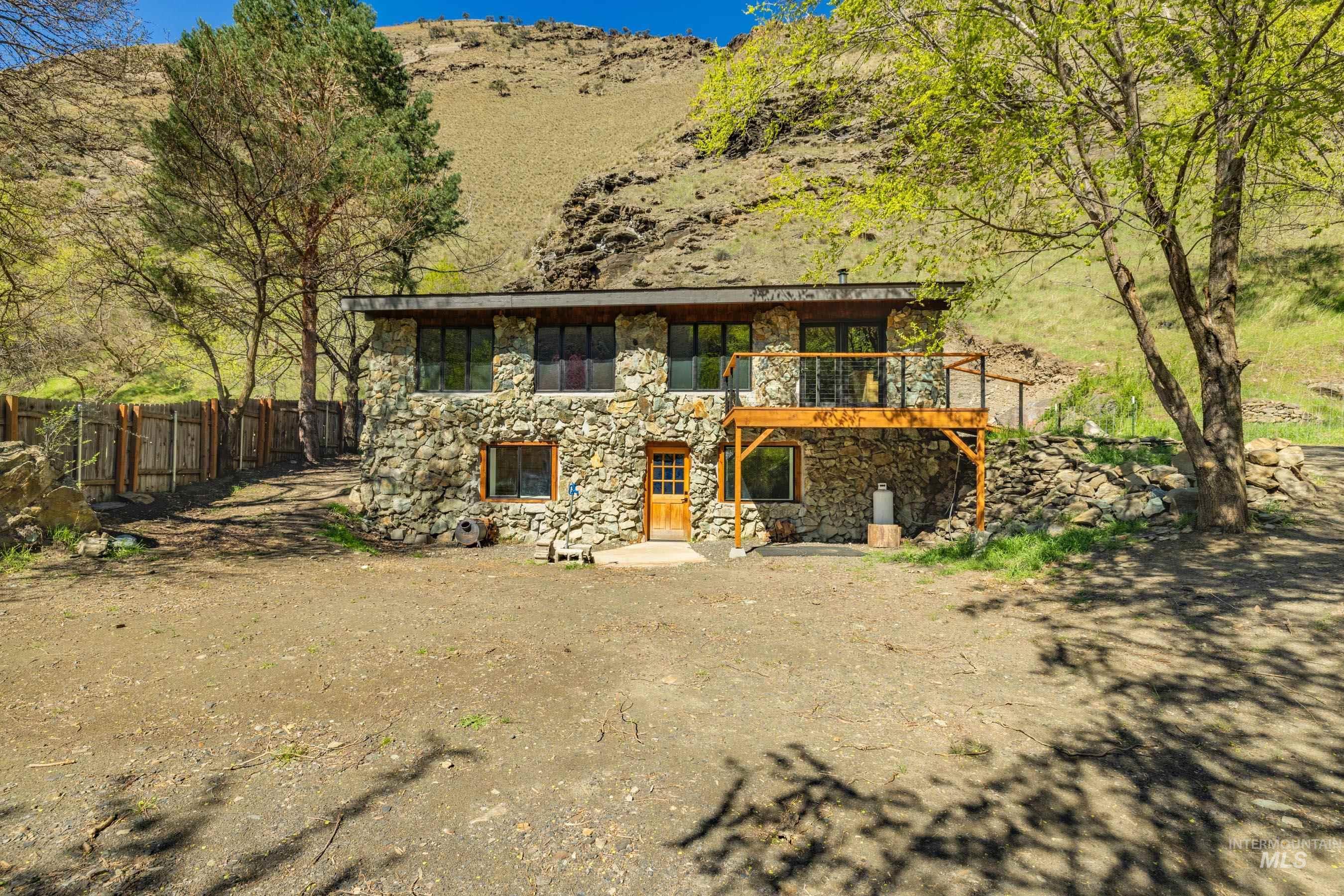 543 North Main Street Riggins, ID 83549 - Photo 2 of 46 View of front of home featuring stone siding, a patio, and a mountain view