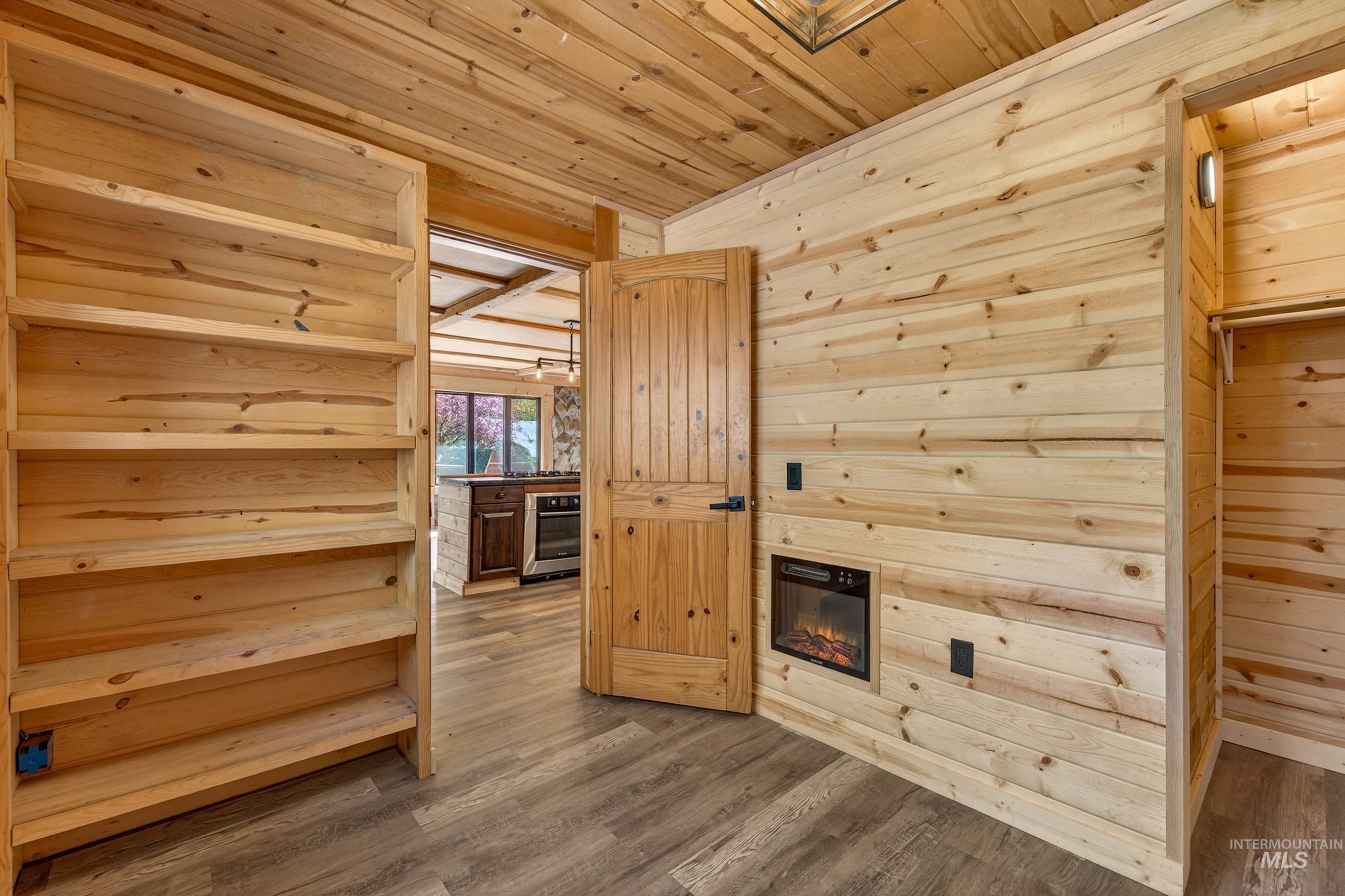 543 North Main Street Riggins, ID 83549 - Photo 27 of 46 Additional living space featuring wood finished floors, wood ceiling, a glass covered fireplace, and wood walls
